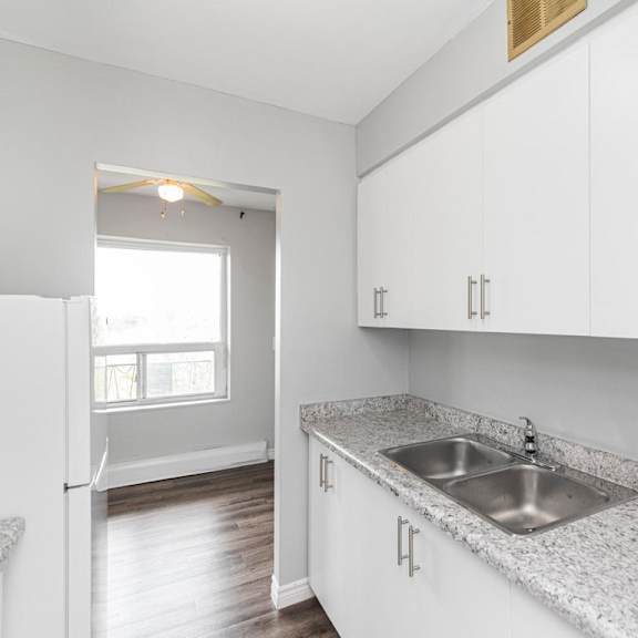 a kitchen with white cabinets and a granite countertop.