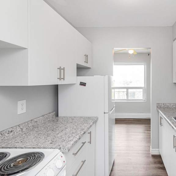 a kitchen with white cabinets and a granite countertop.