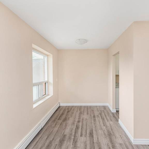 a room with a window and wooden flooring.