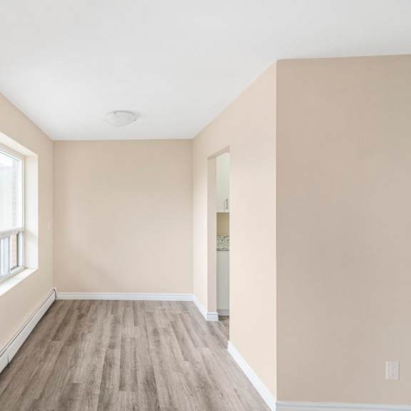 a room with a window and wooden flooring.