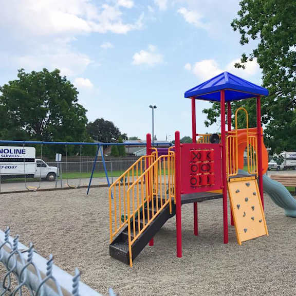 a playground with a red and yellow slide and a blue and yellow tower.