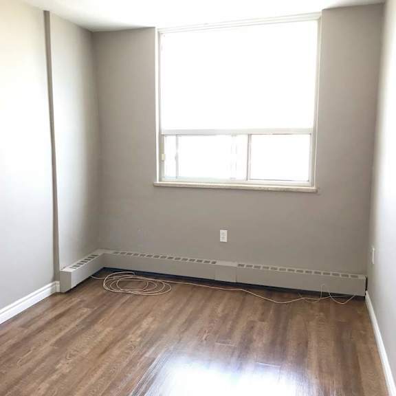 a room with a window and a radiator on the floor.