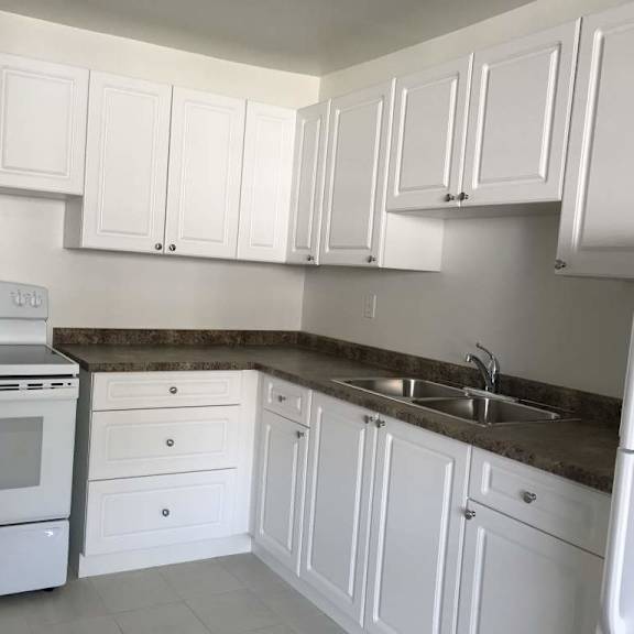 a kitchen with white cabinets and a stainless steel oven.