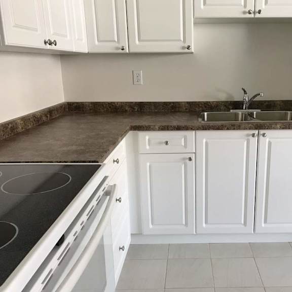 a kitchen with white cabinets and a granite countertop.