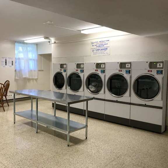 a laundry room with washers and dryers and a table and chairs.
