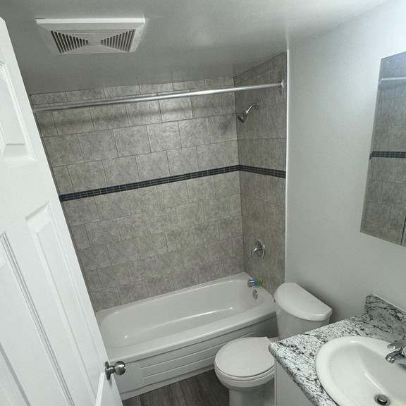 a bathroom with a toilet, sink, and bathtub.