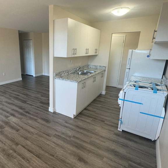 a room with a kitchenette and a refrigerator.
