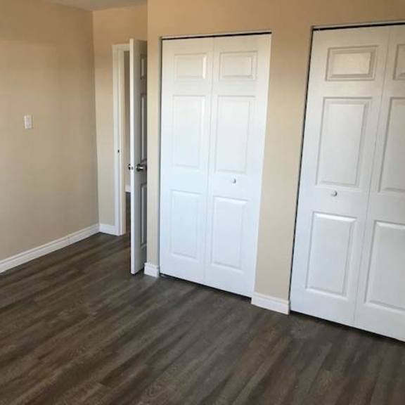 a room with a white door and a brown floor.