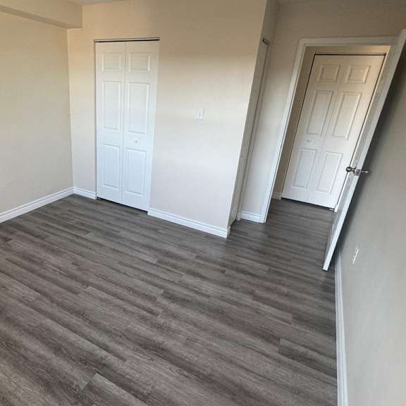 a room with a grey floor and two white doors.