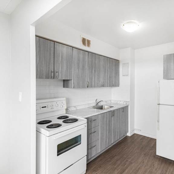 a white kitchen with a stove, oven, and refrigerator.