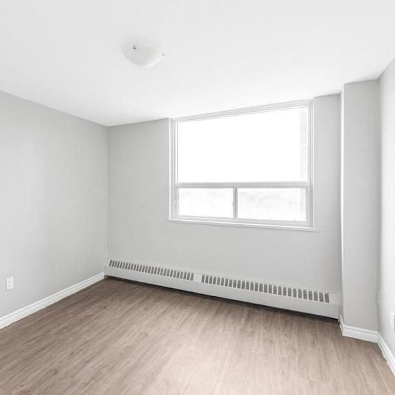 a room with a window and a radiator on the wall.