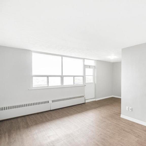 a white room with a window and a door leading to another room.