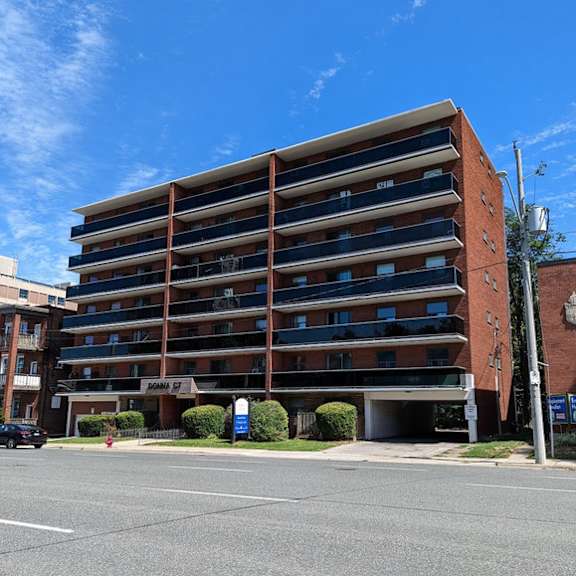 a large red brick building with a parking lot in front.