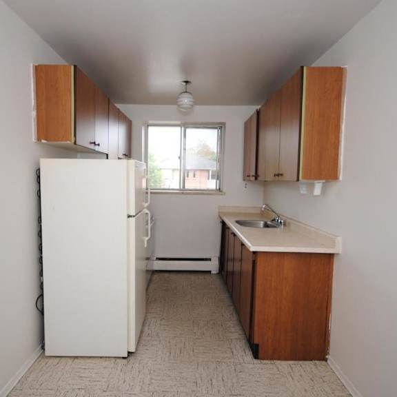 a kitchen with white appliances and wooden cabinets.