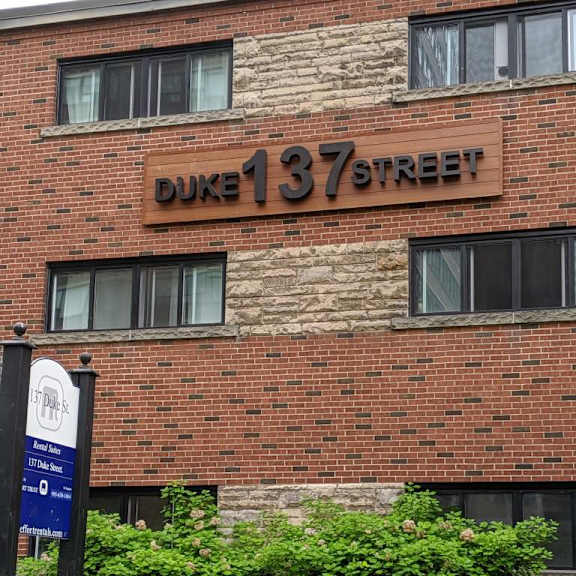 a brick building with a sign that says duke 137 street.