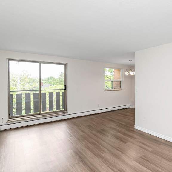 a large empty room with wooden floors and white walls.