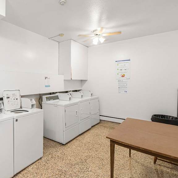 a laundry room with a washer and dryer, sink, and a table.