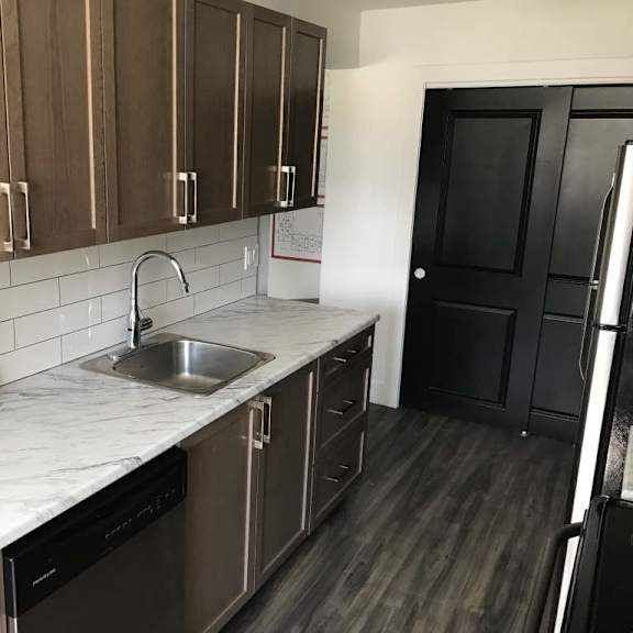 a kitchen with brown cabinets and a marble countertop.