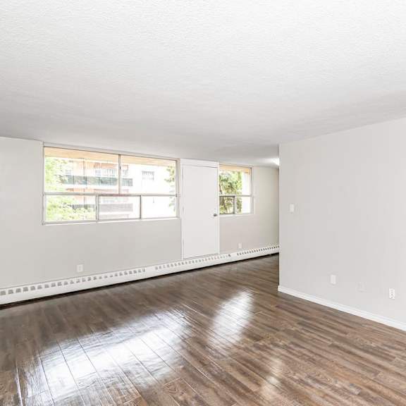 a large empty room with wooden floors and white walls.