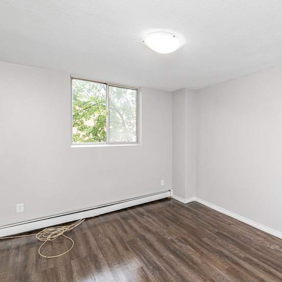 a room with a window and wooden flooring.