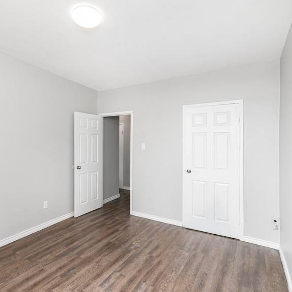 a room with a white door and a brown floor.