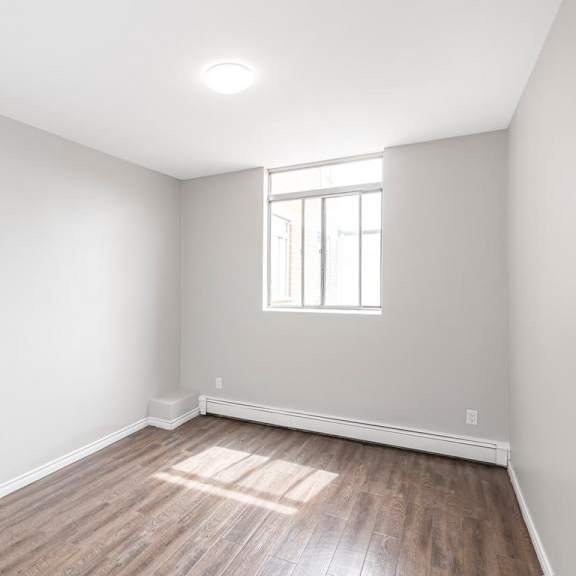 a room with a window and wooden flooring.