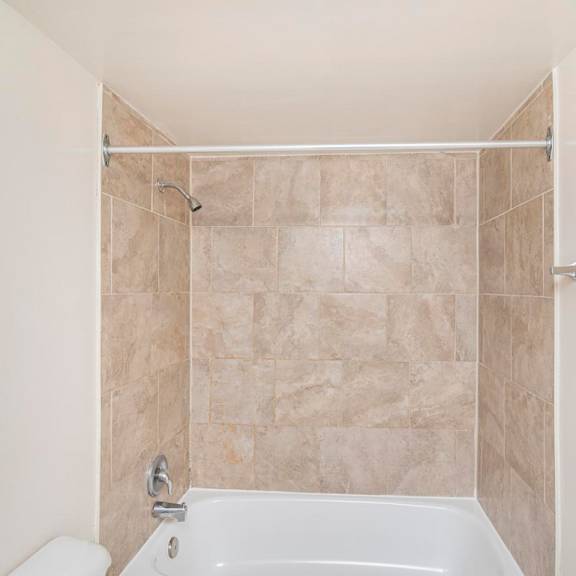 a white bathroom with a tiled shower.