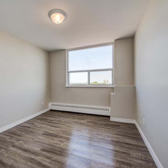 a room with a window and a radiator on the wall.