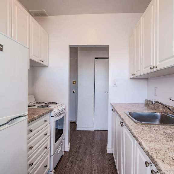 a kitchen with white cabinets and a granite countertop.