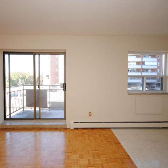 a room with a wooden floor and a window with blinds.