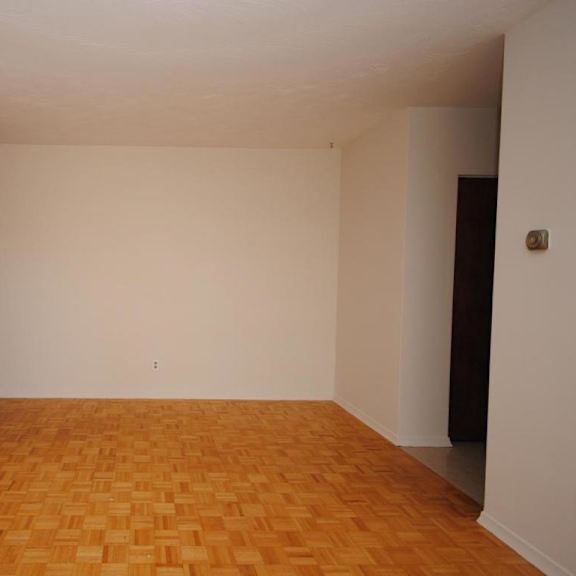 empty room with wooden floor and white walls.
