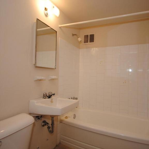 a white bathroom with a tub, sink, and toilet.