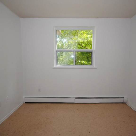 a room with a window and a white wall.