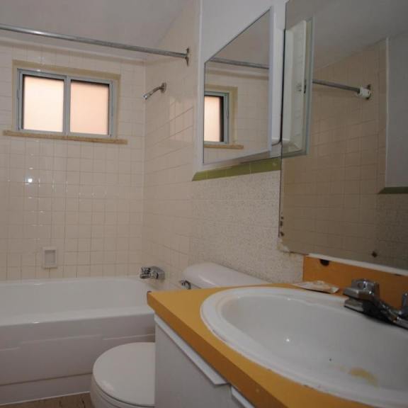 a white bathtub sits next to a toilet in a bathroom.
