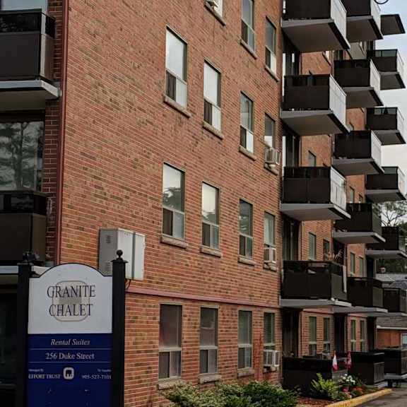 a brick building with balconies and a sign that says granite chalet.