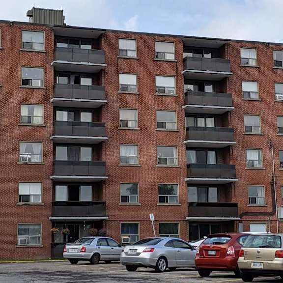a red brick building with a parking lot in front of it.