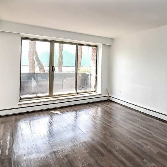 a room with a window and a wooden floor.