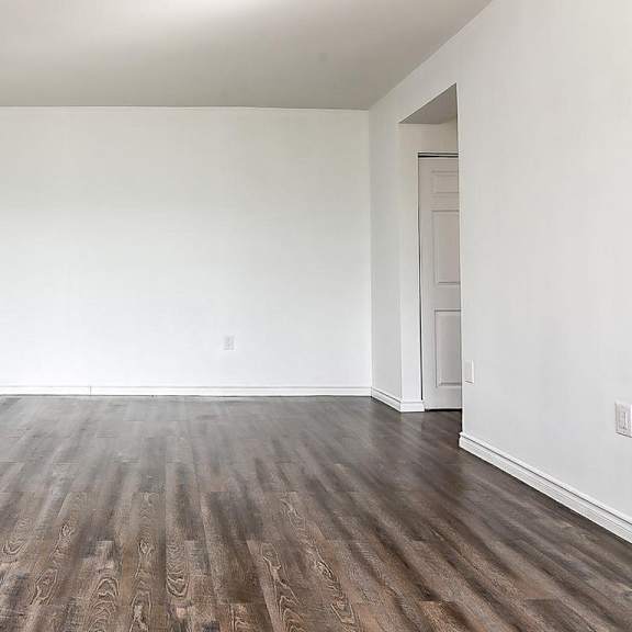 a room with wooden flooring and white walls.