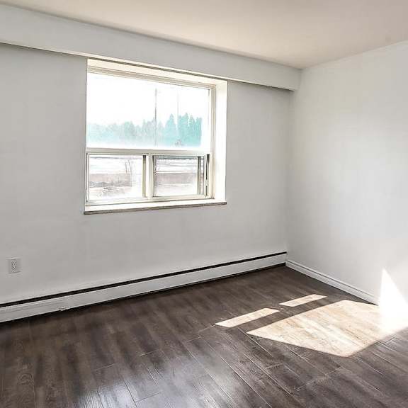 a room with a window and wooden flooring.