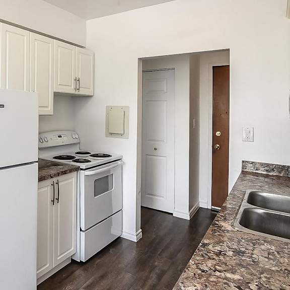 a white refrigerator is in a kitchen with white cabinets.