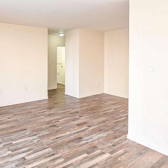 a room with wooden flooring and white walls.