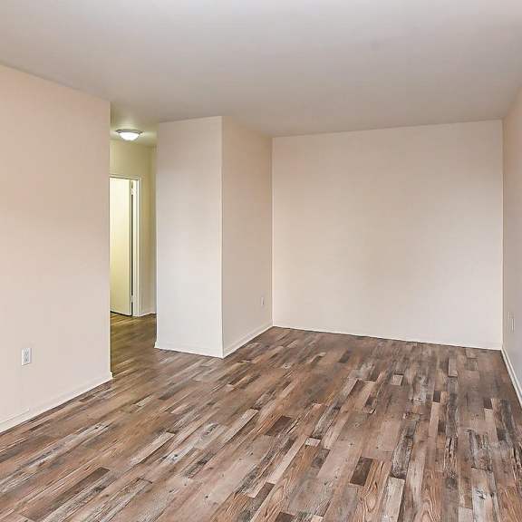 a room with wooden flooring and a doorway leading to another room.