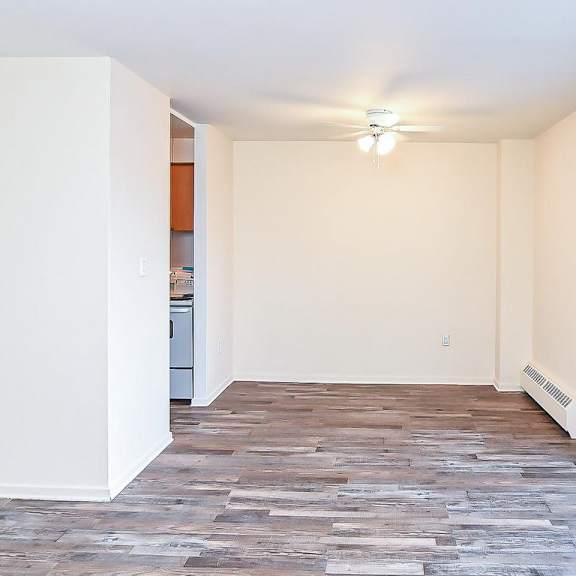 a room with a wooden floor and a window overlooking a snowy street.