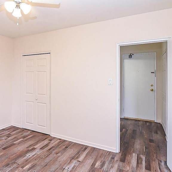a room with a ceiling fan and two doors.