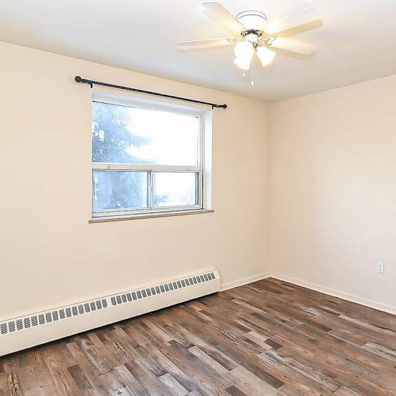 a room with a window and a ceiling fan.