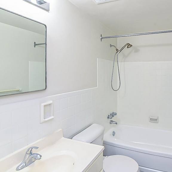 a white bathroom with a toilet, sink, and bathtub.