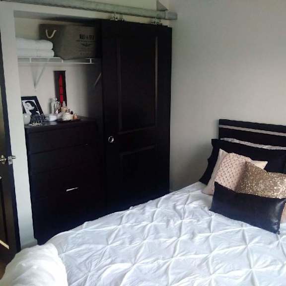 a bedroom with a bed, nightstand, and wardrobe.
