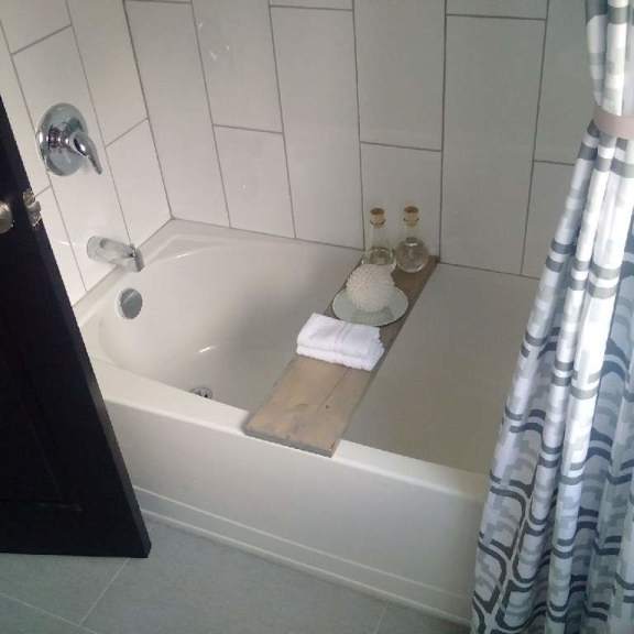 a white bathtub with a wooden plank in it.