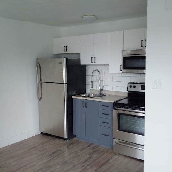 a kitchen with a refrigerator, stove, and microwave.