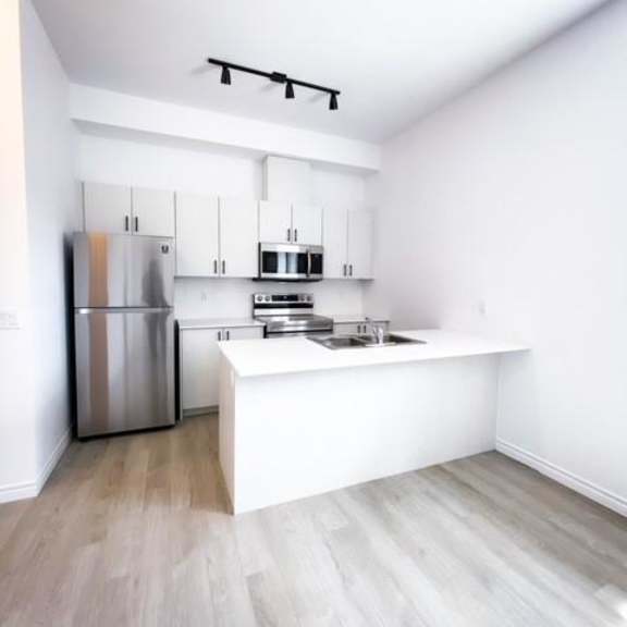 a kitchen with a refrigerator, microwave, and oven.